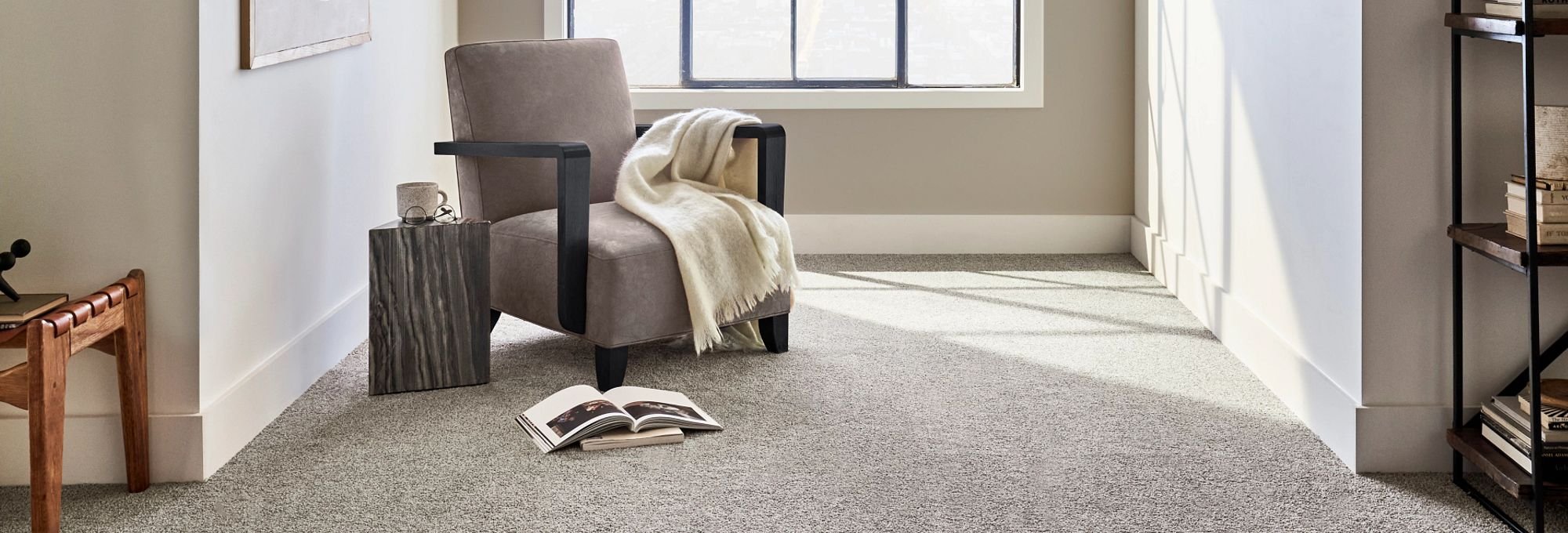 Gray armchair next to a window in a room with gray carpet from Brennan's Carpet in Hailey, ID